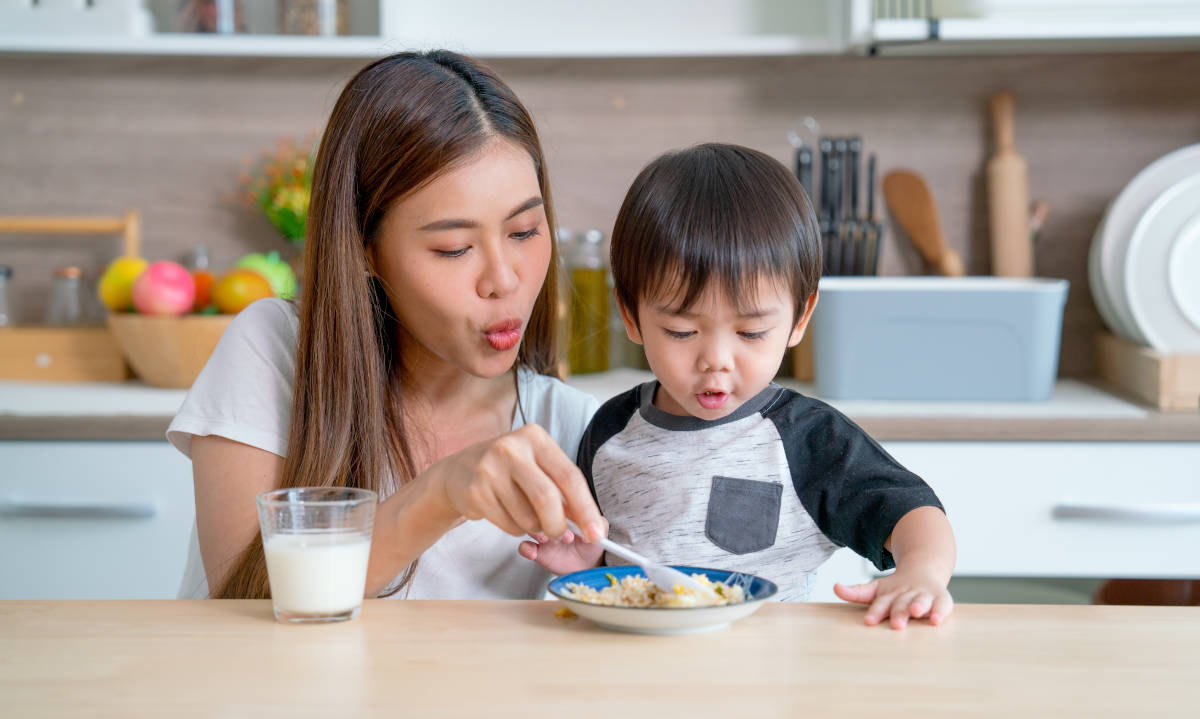 Seorang ibu sedang menemani anak makan