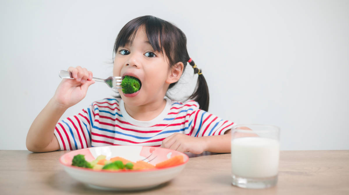 Seorang anak sedang makan makanan sehat