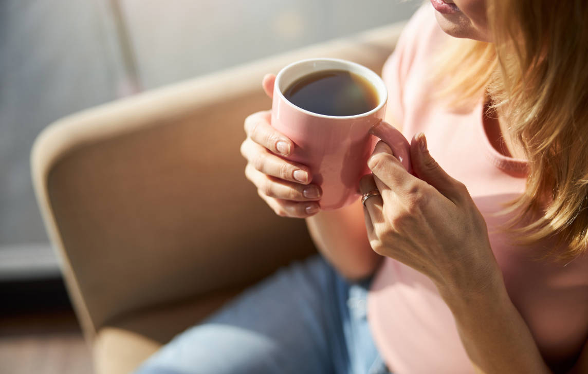Seorang wanita minum kopi