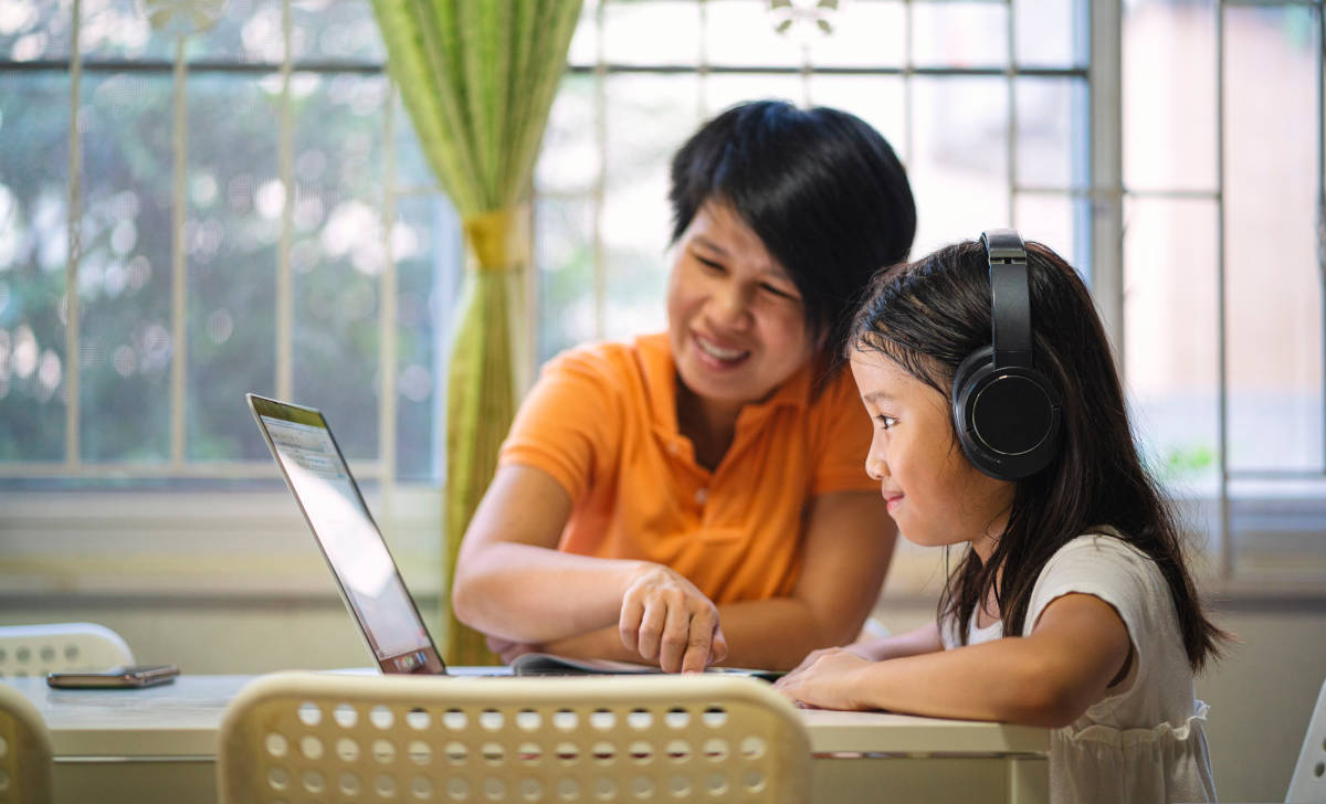 Seorang anak sedang belajar ditemani ibunya