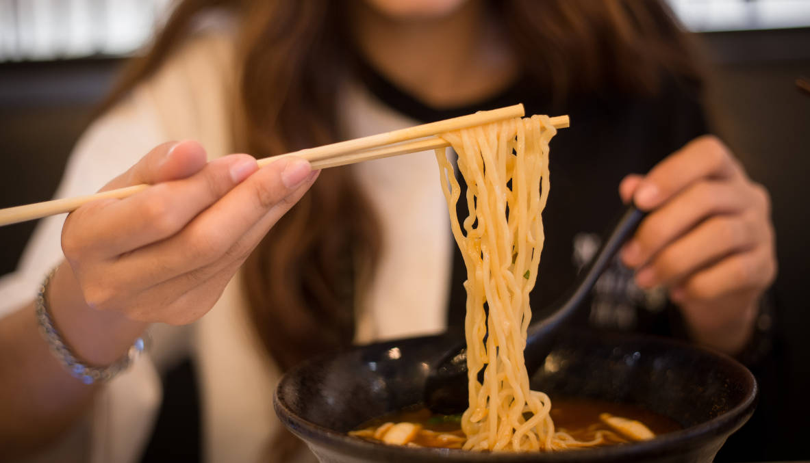 Seorang wanita makan mie instant
