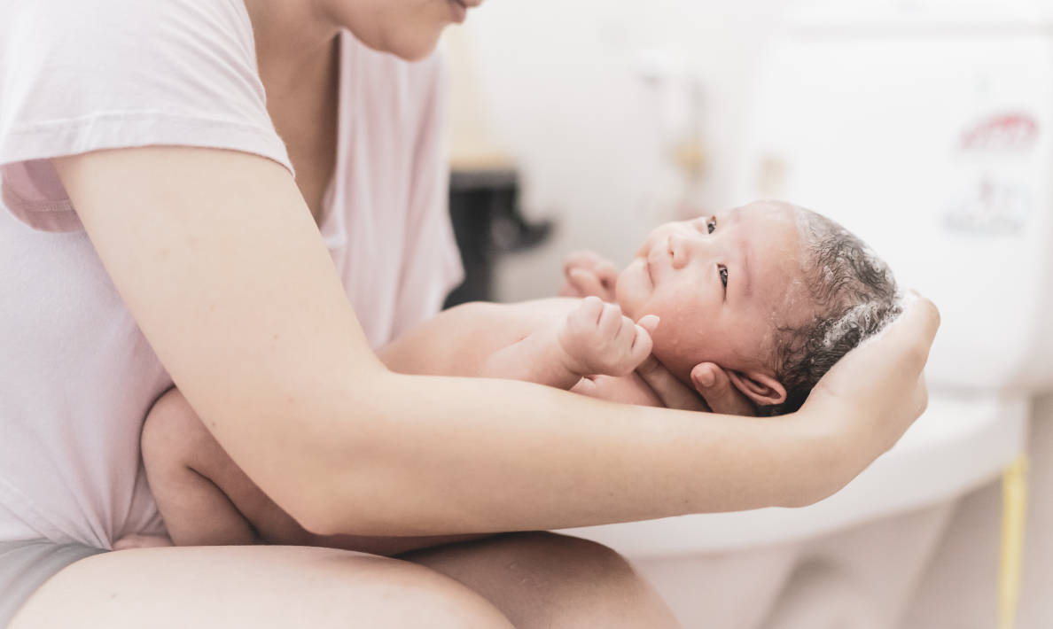 Seorang ibu sedang memandikan bayi baru lahir