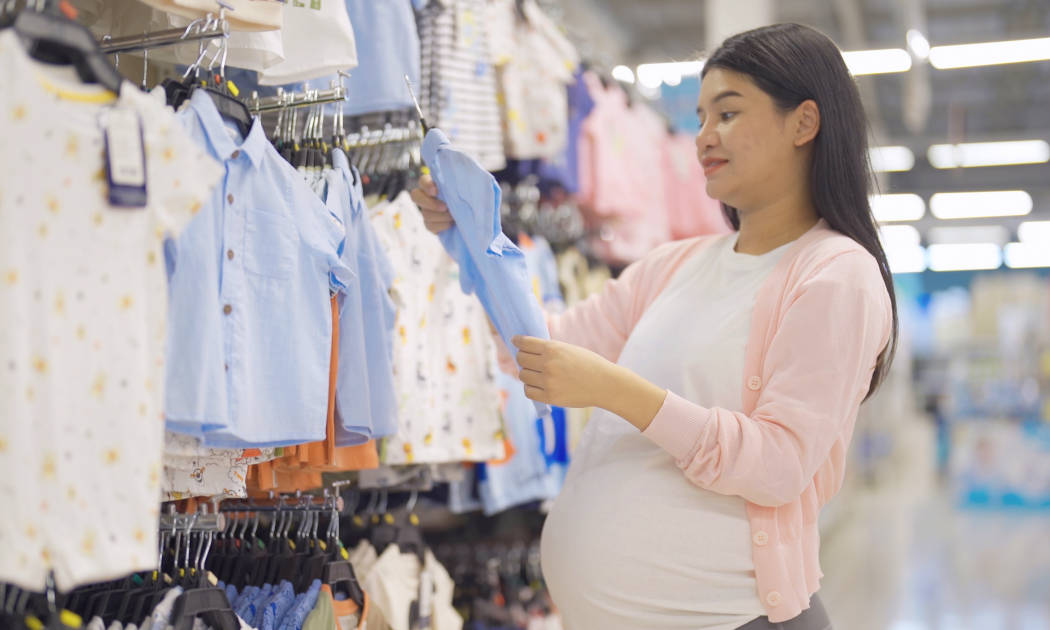 Ibu hamil sedang berbelanja baju bayi
