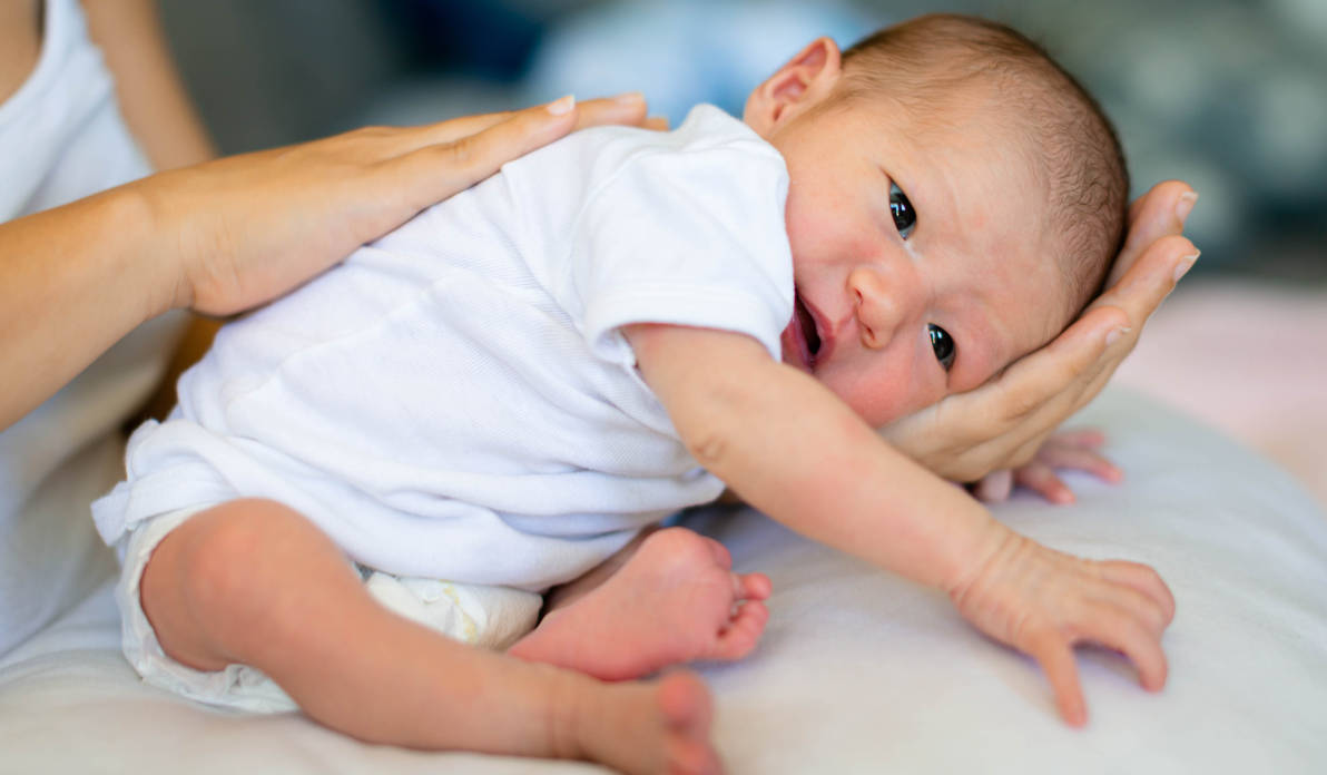 Seorang ibu sedang menyendawakan bayi