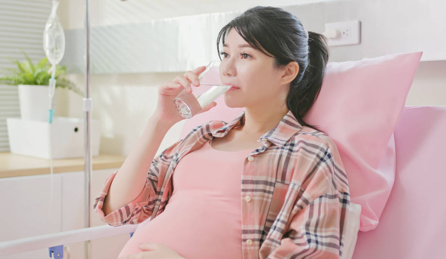 Ibu hamil sedang minum air putih