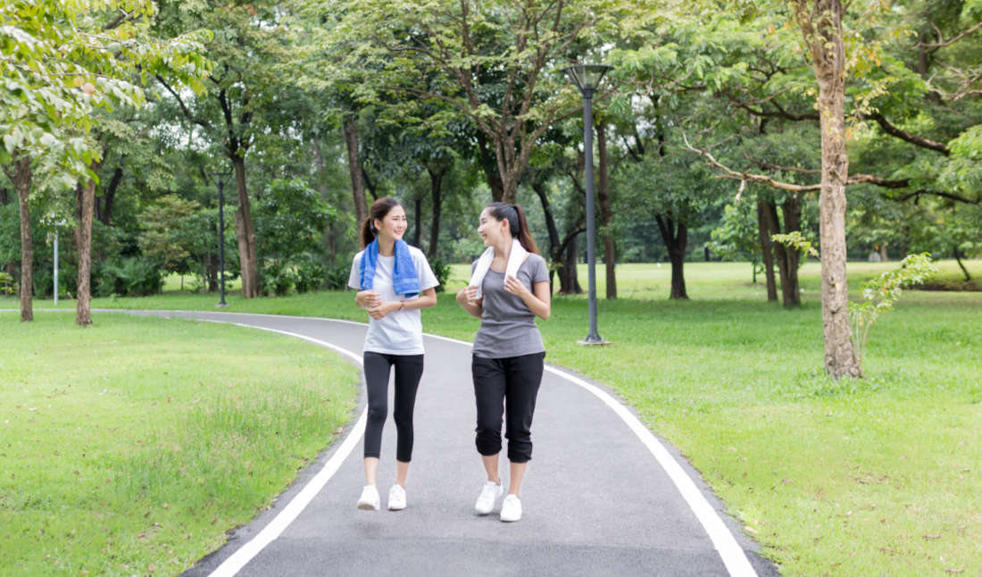 Wanita berjalan kaki di taman